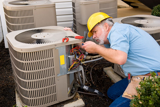 service technician repairing air conditioning condenser